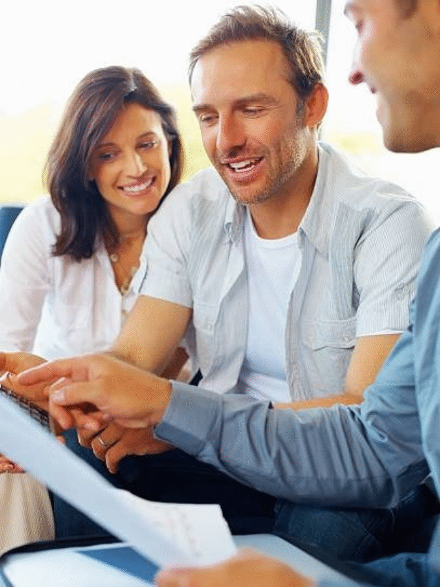Couple discussing paperwork with advisor