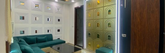 Living room with teal sofa, LED ceiling, and wall decor