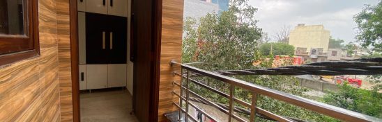 Small balcony with wood-look tiles and railing.