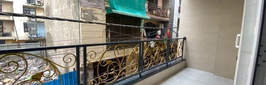Balcony with tiled floor and iron railing.