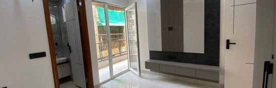 Modern bedroom with TV panel and balcony access.