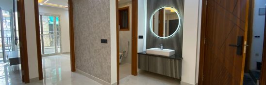 Modern hallway with mirror sink and multiple doors.