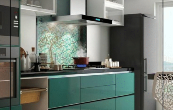 Modern modular kitchen with green cabinets and mosaic backsplash.